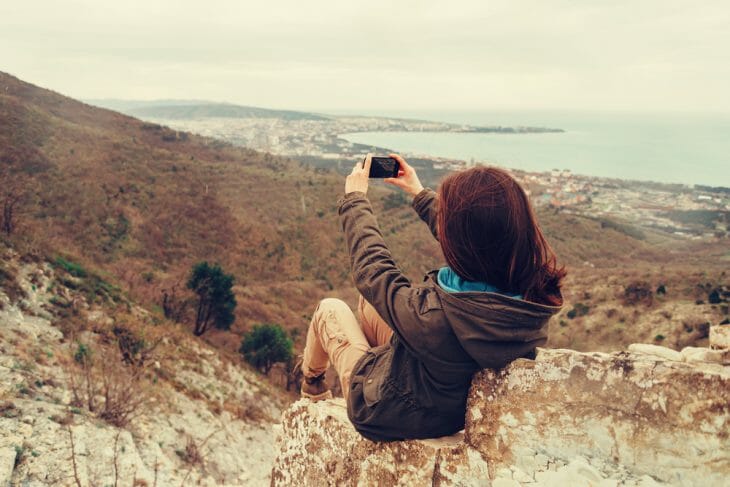 Девушка фотографирует пейзаж